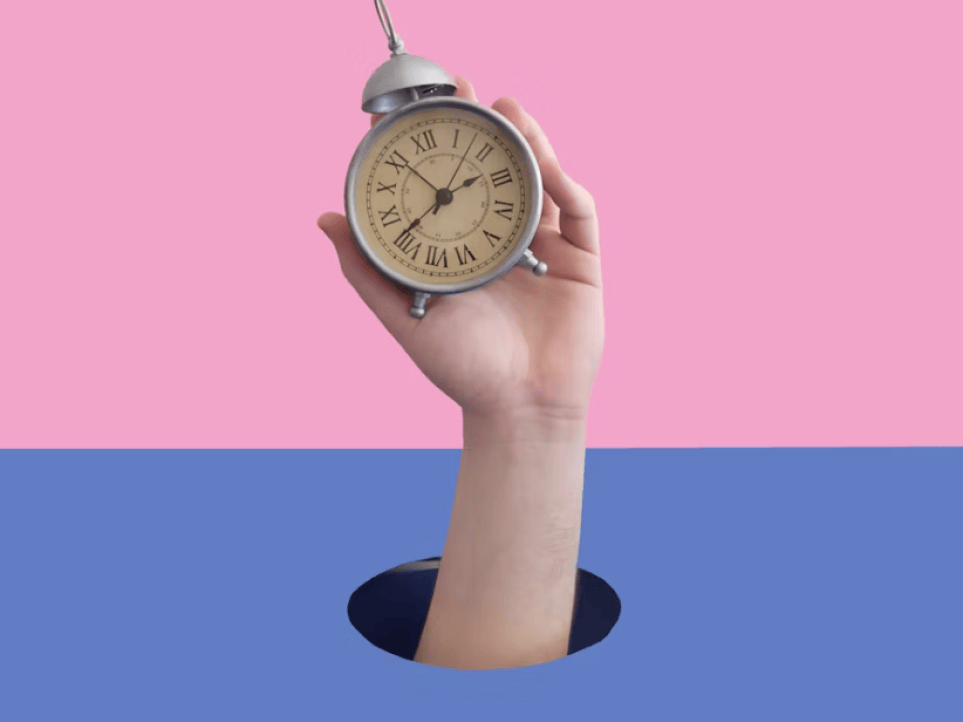 A hand is holding a clock