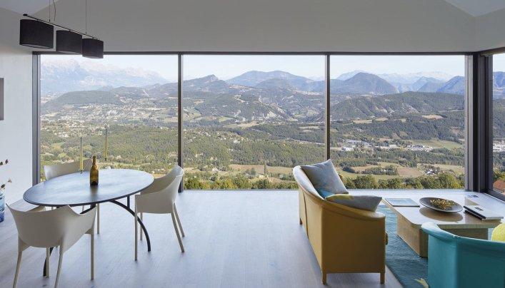 Picture of a room with glass walls and a landscape in the background