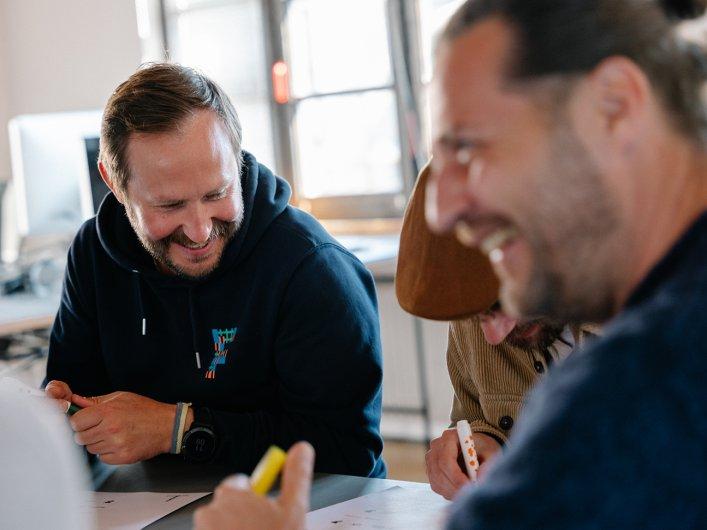 Drei Mitarbeitende von Factorial sitzen gemeinsam in einem Workshop.