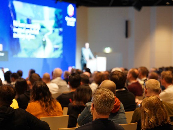 Teilnehmende bei der Drupalcon Vienna 2025 im Hauptraum mit Blick auf die Bühne. Foto von Joris Vercammen.