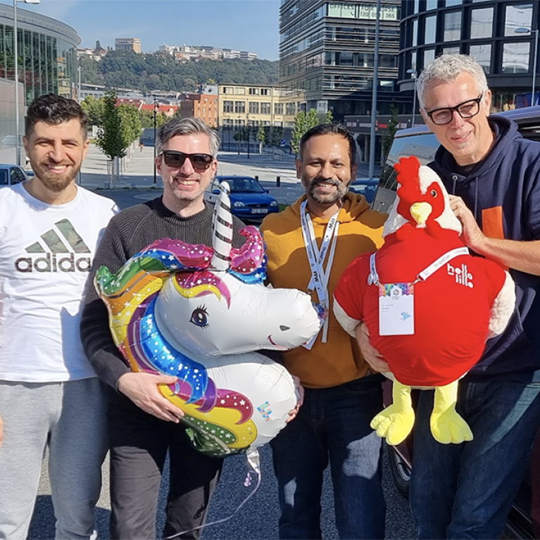 Factorial team on their visit to DrupalCon Prague 2022, holding the lille rooster mascot.