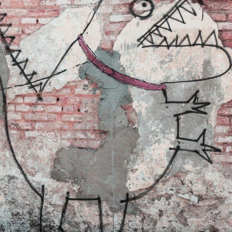 Streetart an Mauer, zu sehen ist ein Kind, dass ein Monster an der Leine hält