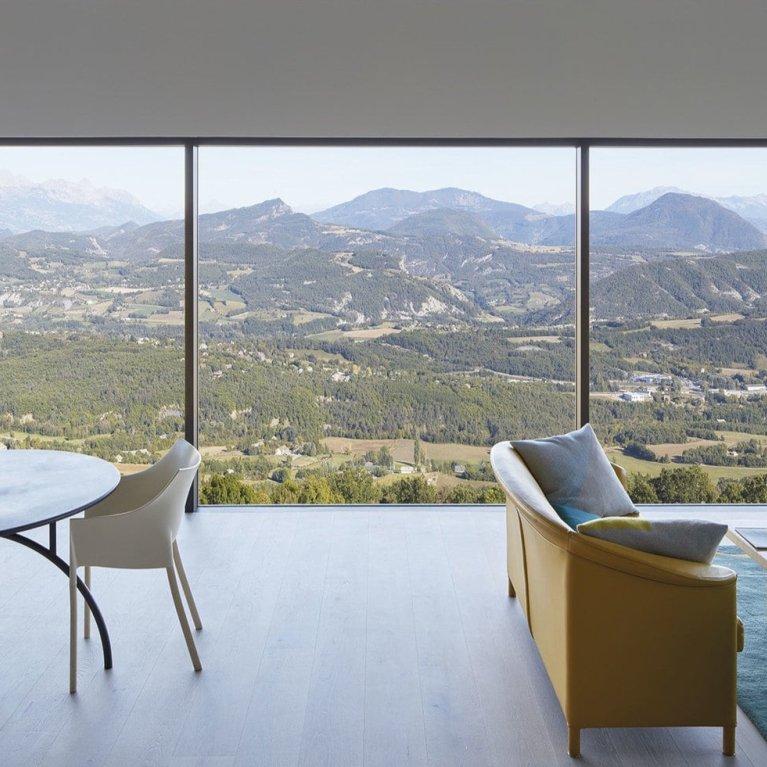 Picture of a room with glass walls and a landscape in the background