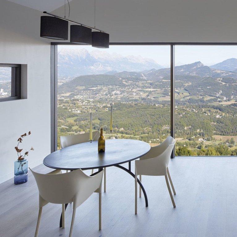 Picture of a room with glass walls and a landscape in the background