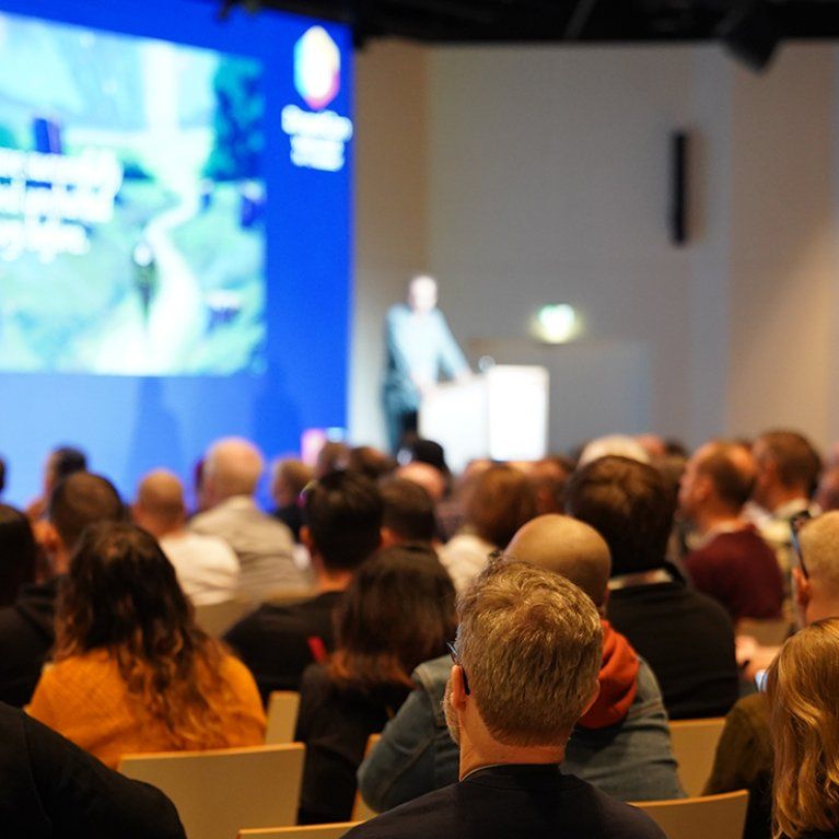 Teilnehmende bei der Drupalcon Vienna 2025 im Hauptraum mit Blick auf die Bühne. Foto von Joris Vercammen.