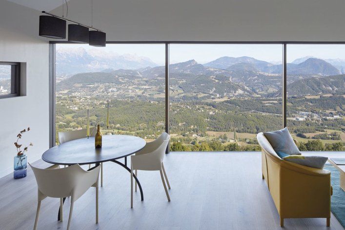 Picture of a room with glass walls and a landscape in the background