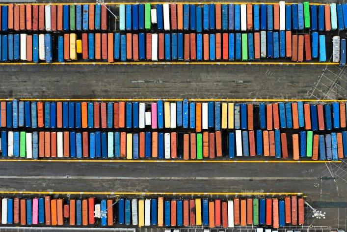Aerial view of neatly arranged, color-coded shipping containers in parallel rows, symbolizing organized digital asset management and structured storage systems.